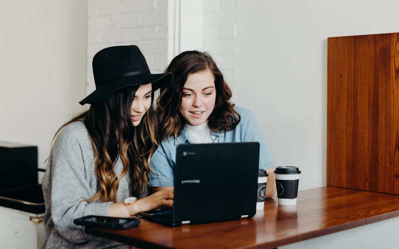 Two colleagues working through a task on a laptop
